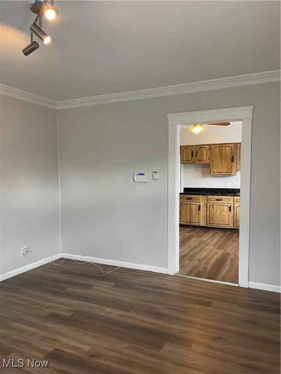 empty room featuring crown molding and dark hardwood / wood-style floors