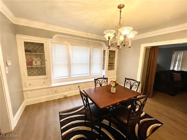 dining room featuring crown molding, dark wood-type flooring, and a notable chandelier