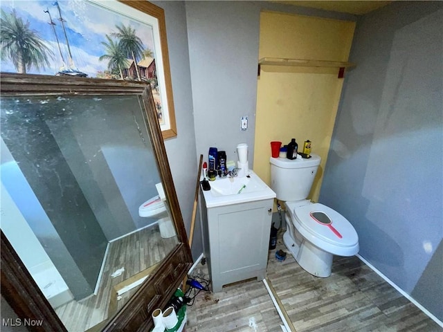 bathroom with hardwood / wood-style flooring, vanity, and toilet