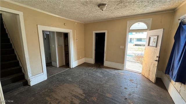 foyer with crown molding and a textured ceiling