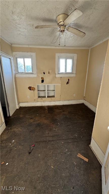 spare room with crown molding, a wealth of natural light, and a textured ceiling