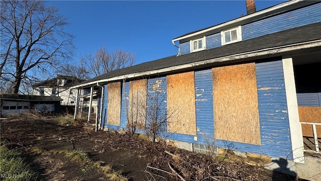 view of side of home featuring an outbuilding