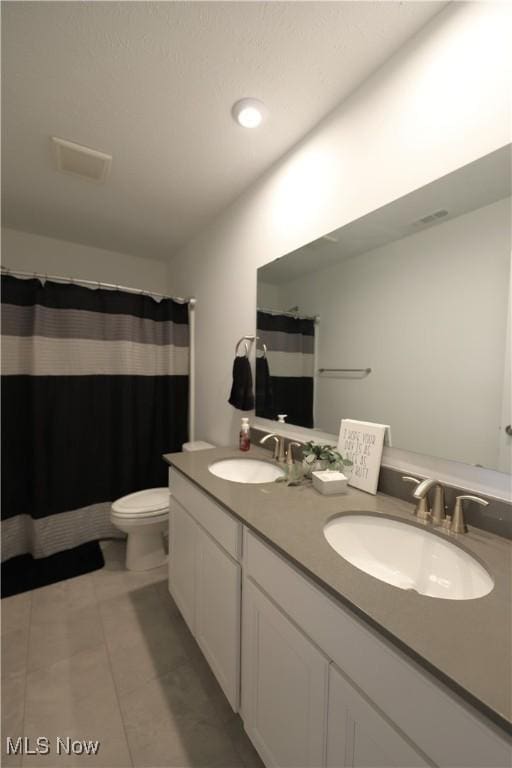 bathroom featuring vanity, walk in shower, tile patterned floors, and toilet