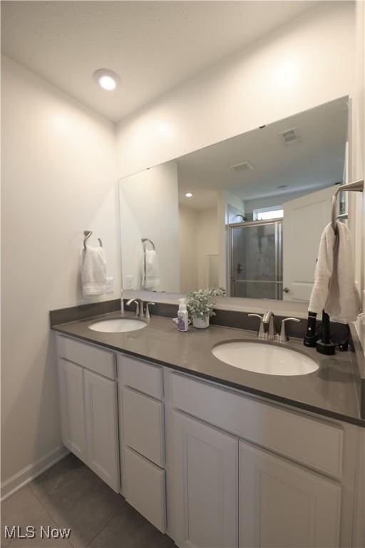 bathroom with vanity, a shower with shower door, and tile patterned floors