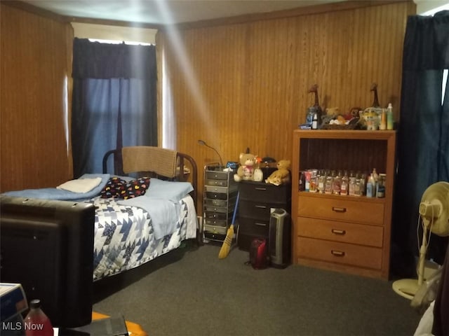 bedroom with carpet and wood walls