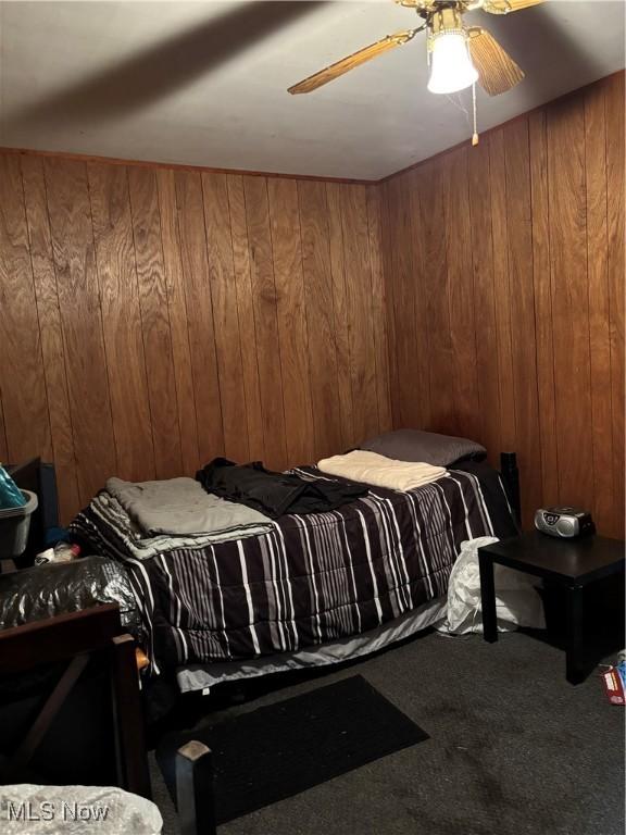428 Foster Ave, Cambridge, OH 43725 - carpeted bedroom featuring wooden walls and ceiling fan