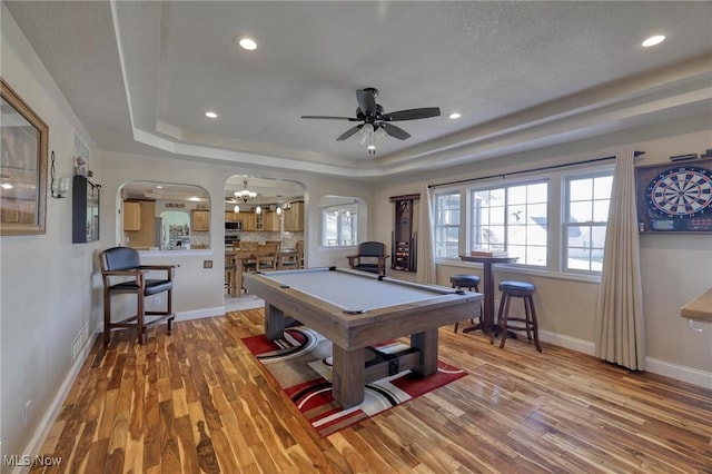 rec room with ceiling fan, pool table, light hardwood / wood-style floors, and a raised ceiling