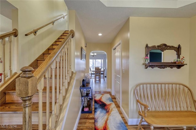 hallway with hardwood / wood-style flooring and a textured ceiling