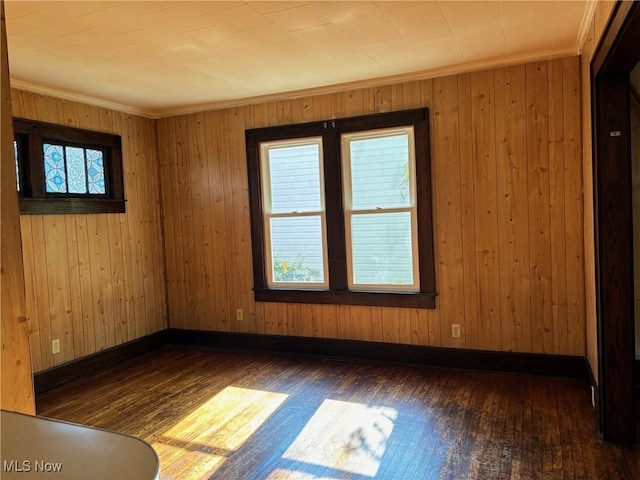 spare room with dark wood-type flooring and ornamental molding