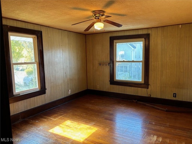 unfurnished room featuring ceiling fan, dark hardwood / wood-style flooring, and a textured ceiling