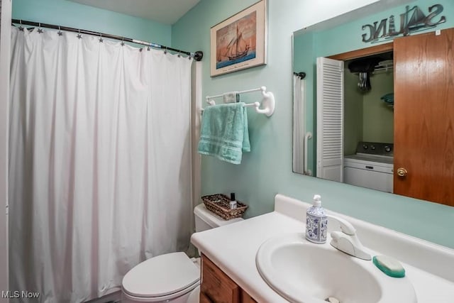 bathroom with vanity, washer / dryer, and toilet