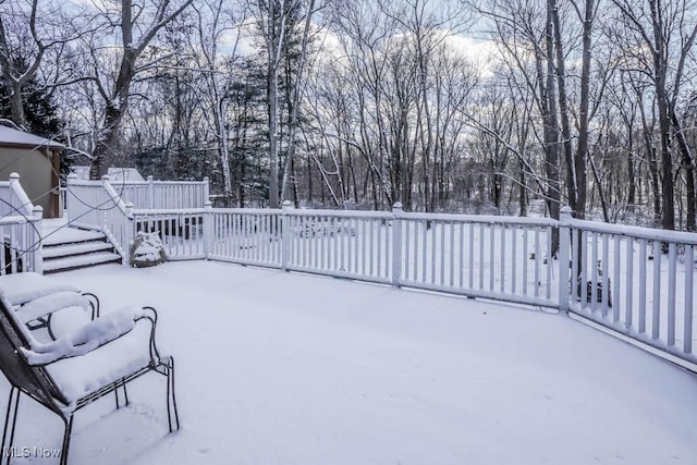 snow covered patio with a deck