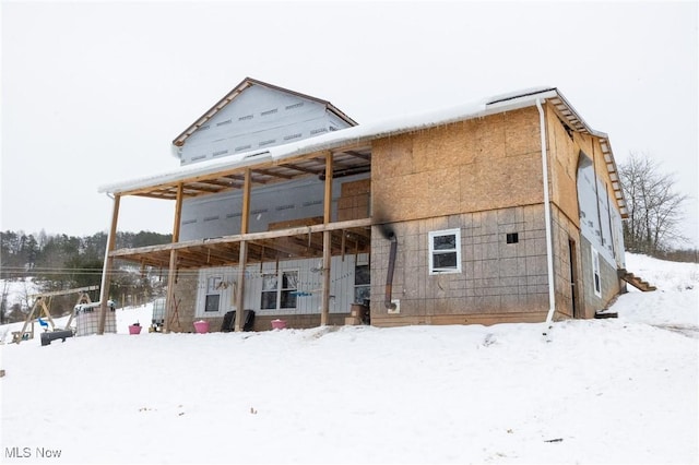 view of snow covered back of property