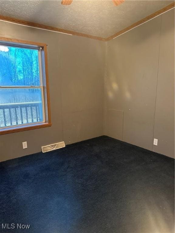 carpeted empty room with a textured ceiling