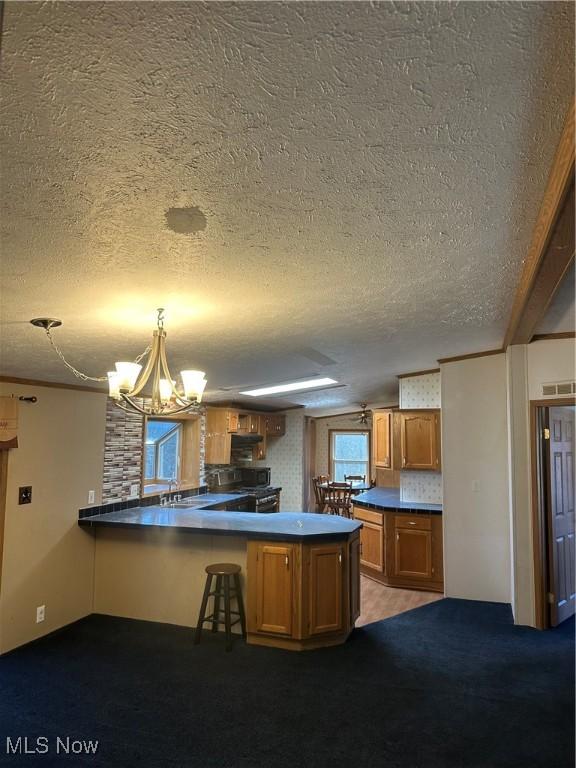 kitchen featuring an inviting chandelier, kitchen peninsula, sink, and hanging light fixtures