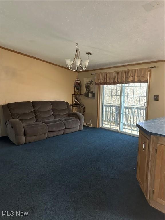 unfurnished living room featuring ornamental molding, an inviting chandelier, and dark carpet