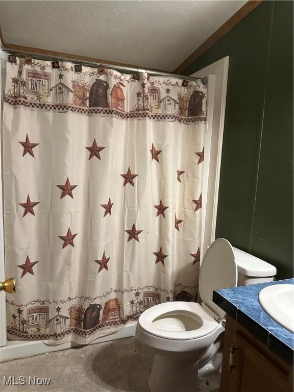 bathroom with toilet, a shower with curtain, a textured ceiling, vanity, and tile patterned flooring