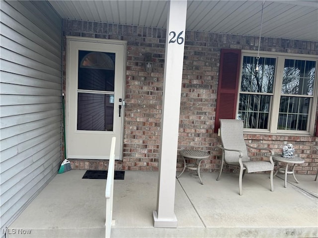 6695 Clingan Rd Unit 26, Poland, OH 44514 - property entrance with brick siding and a porch