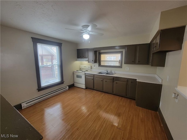 kitchen featuring electric stove, light countertops, a baseboard heating unit, light wood-style floors, and a sink