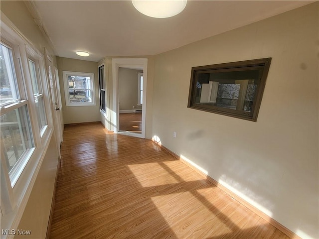 hall with baseboards and wood finished floors