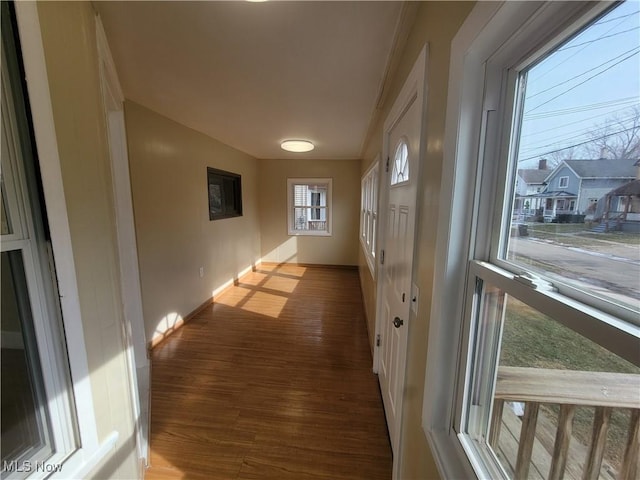 hallway with dark wood-style flooring and baseboards