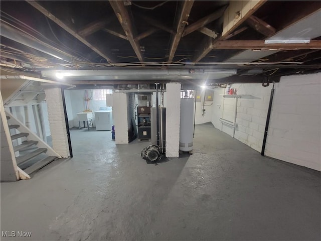 basement featuring stairs, washer / clothes dryer, a sink, and gas water heater