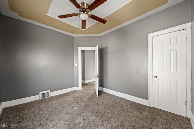 carpeted spare room with ceiling fan and ornamental molding