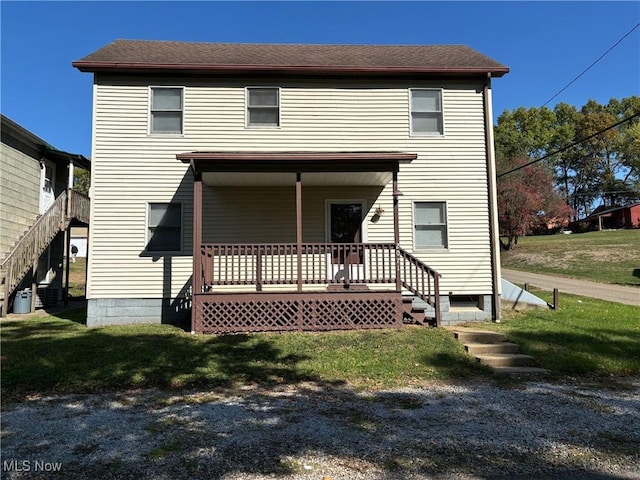 back of property with a porch and a yard