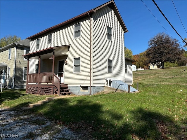 rear view of property featuring a lawn