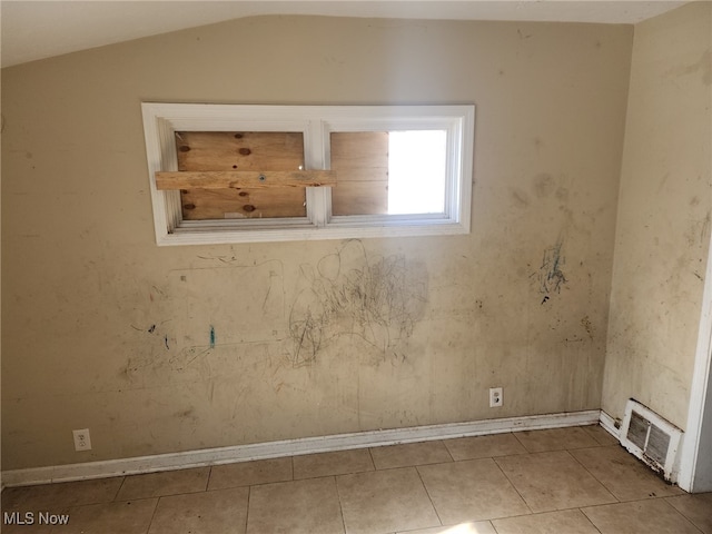 unfurnished room featuring lofted ceiling