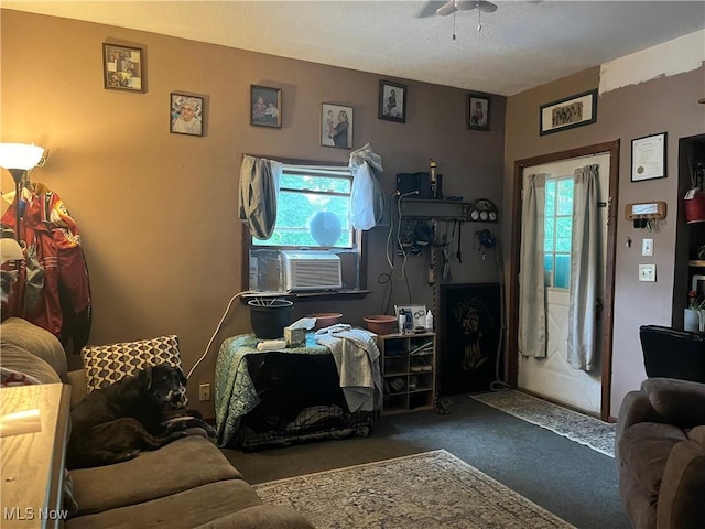 living room featuring cooling unit, dark carpet, and ceiling fan