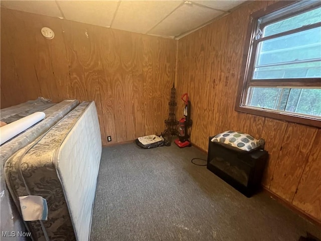 unfurnished bedroom with wooden walls and carpet