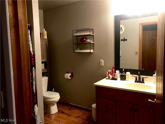 bathroom featuring vanity, hardwood / wood-style flooring, and toilet