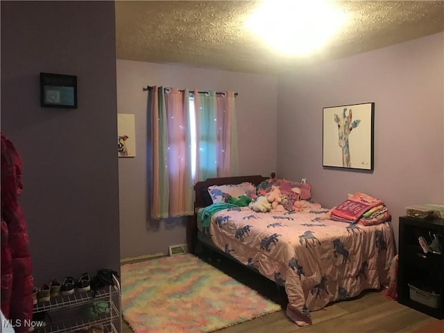 bedroom featuring hardwood / wood-style floors and a textured ceiling