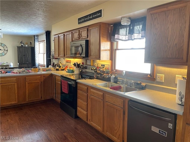 kitchen with dark hardwood / wood-style flooring, sink, a textured ceiling, and black appliances