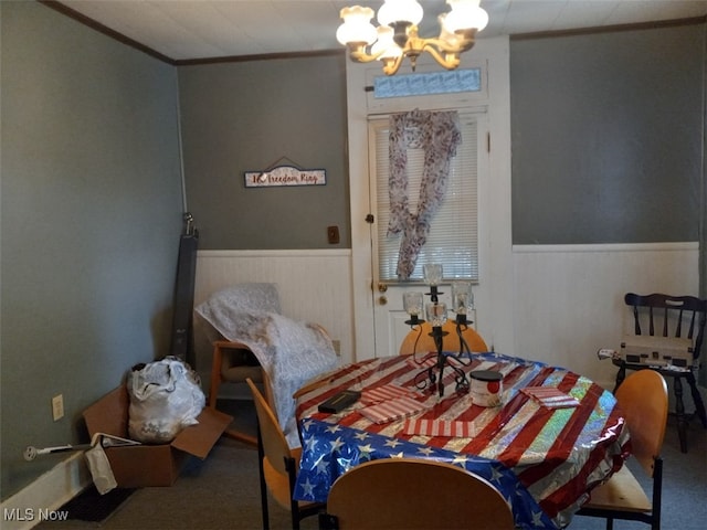 dining room with a notable chandelier, crown molding, and carpet floors