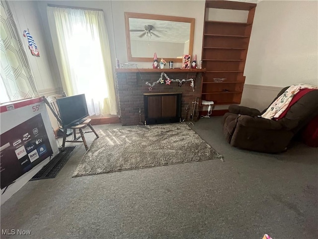 living room with built in shelves and a brick fireplace