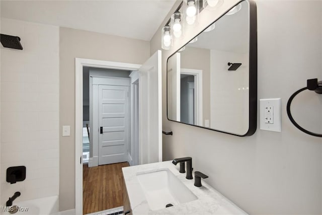 bathroom featuring vanity, wood-type flooring, and bathtub / shower combination