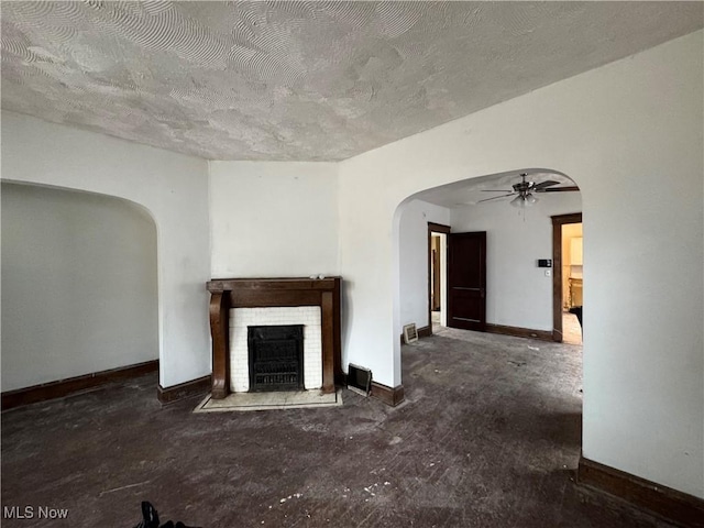 unfurnished living room featuring a textured ceiling and ceiling fan