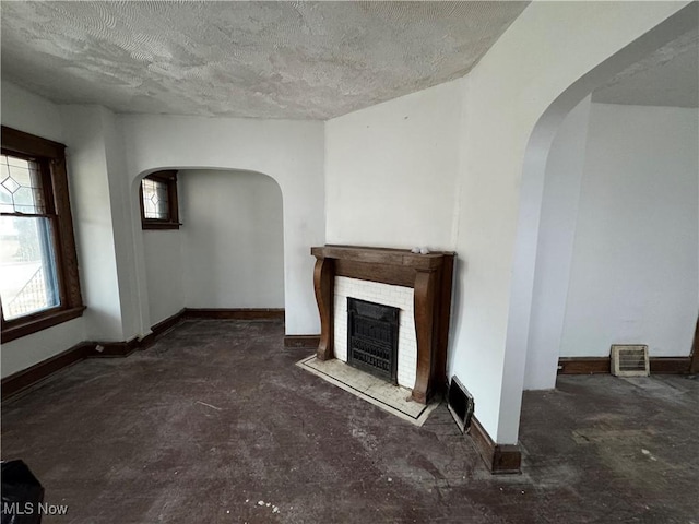 unfurnished living room featuring a fireplace and a textured ceiling