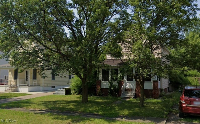 view of property hidden behind natural elements featuring a front lawn