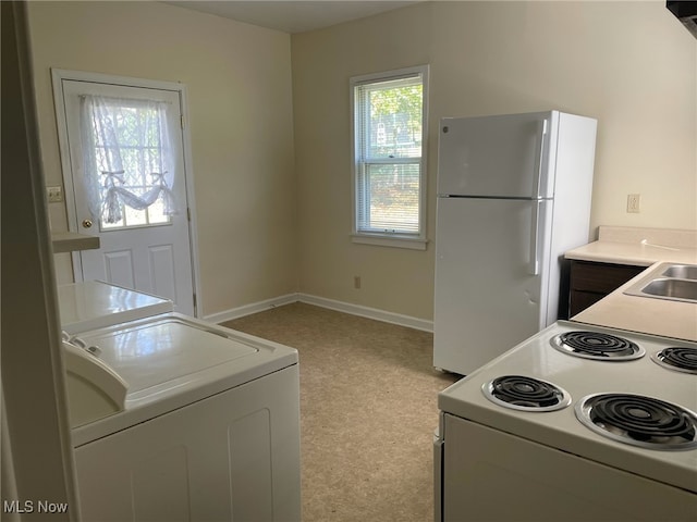 kitchen with washer / clothes dryer and white appliances