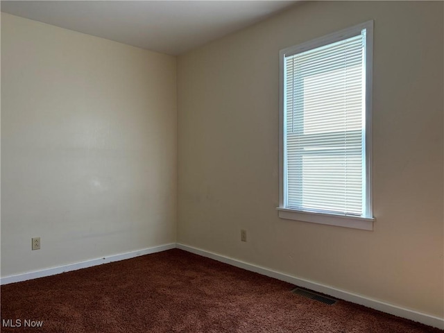 empty room featuring dark colored carpet