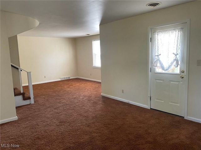 entrance foyer with dark colored carpet