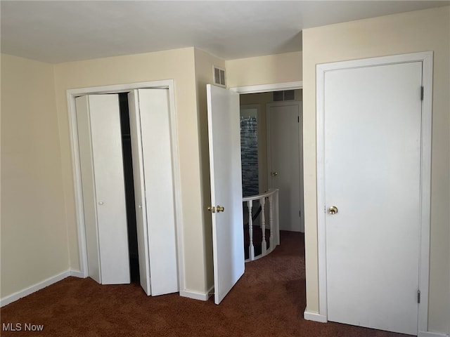 unfurnished bedroom featuring a closet and dark colored carpet