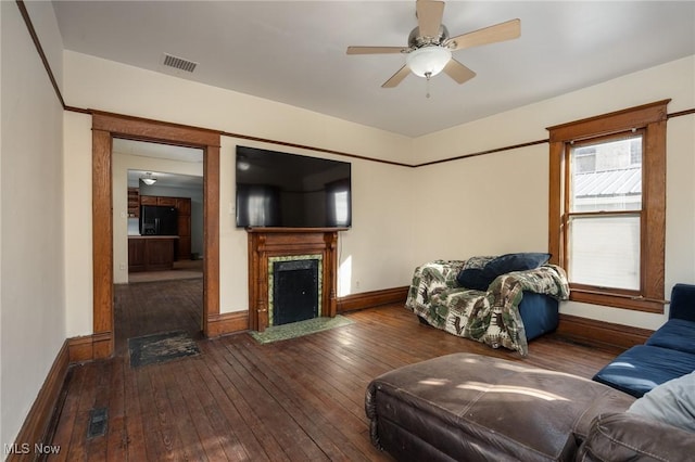 living room with ceiling fan, dark hardwood / wood-style floors, and a fireplace