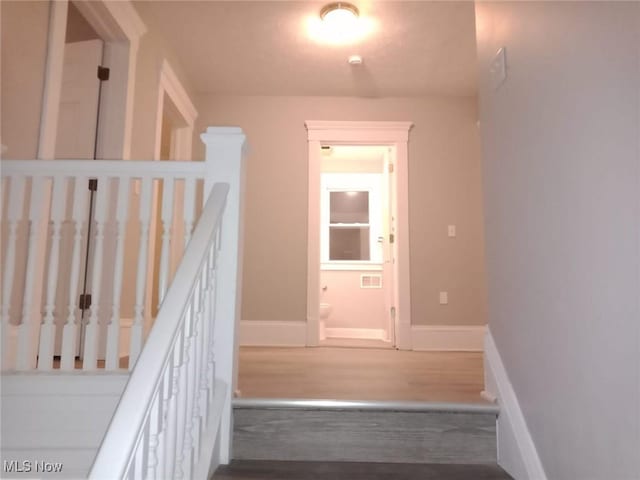 stairway featuring baseboards and wood finished floors