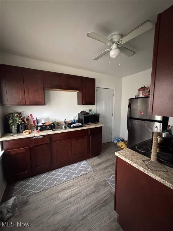 kitchen with sink, stainless steel refrigerator, ceiling fan, and light wood-type flooring