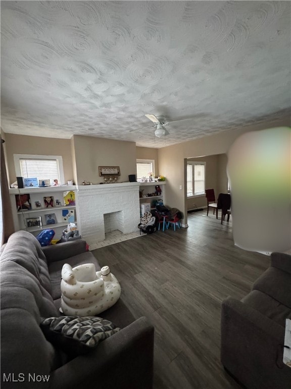 living room featuring hardwood / wood-style flooring, a fireplace, and a textured ceiling