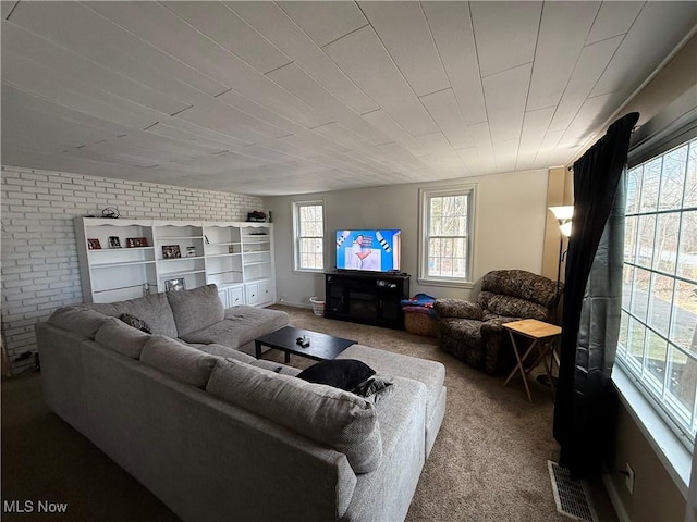 living room featuring brick wall and carpet floors